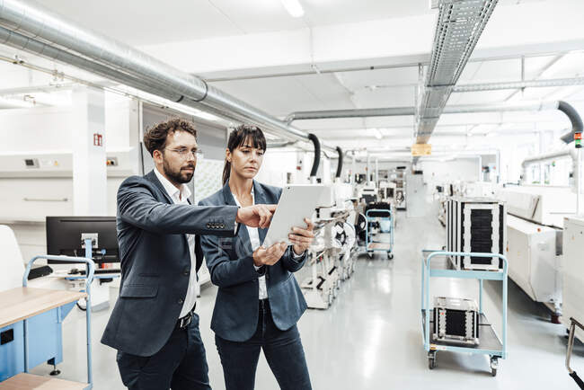 Uomo d'affari che punta al tablet digitale per donna d'affari nell'industria — Foto stock