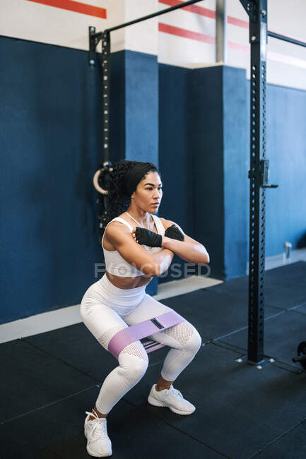 Confident female athlete working out with resistance band in gym — Foto stock