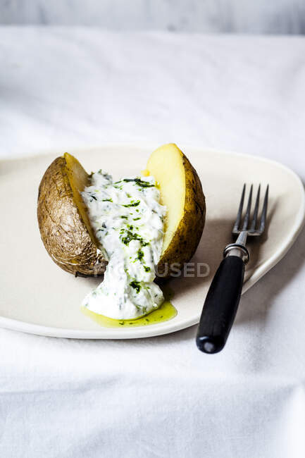 Baked potatoes with lemon and cheese on a white plate — Stock Photo