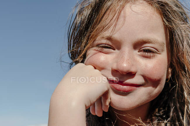 Primer plano de la chica con la mano en la barbilla durante el día soleado - foto de stock