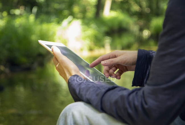 Reifer Mann nutzt digitales Tablet im Sitzen in der Natur — Stockfoto