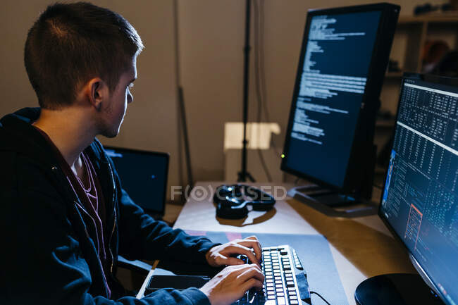 Male hacker looking at computer while working at office — indoors, young  man - Stock Photo | #481413632