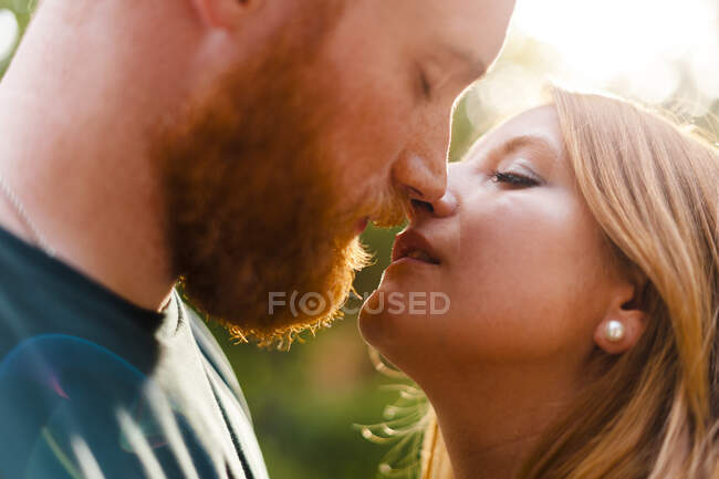 Сердечні гетеросексуальні пари цілуються в парку. — стокове фото