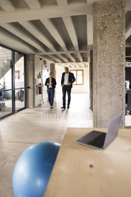 Business people talking while walking in office — Stock Photo