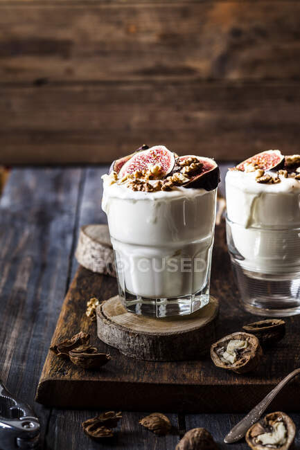 Two glasses of Greek yogurt with honey, figs and walnuts — Stock Photo