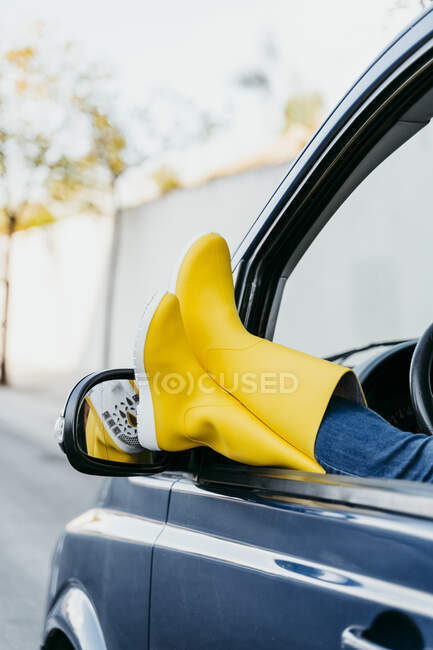 Mulher despreocupada relaxando com as pernas na janela do carro durante a viagem de carro — Fotografia de Stock