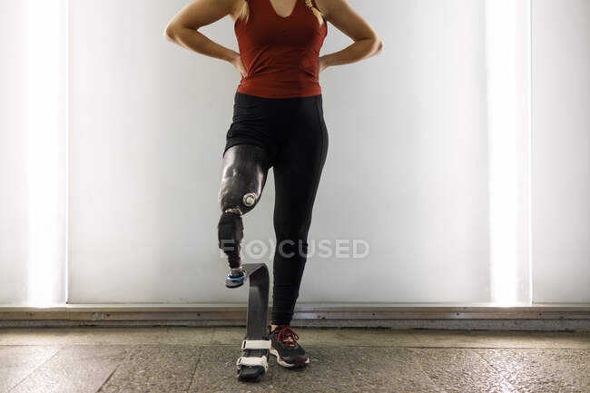 Athlète avec prothèse de jambe debout contre le mur dans le passage inférieur — Photo de stock