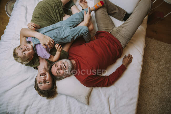 Mère, père et fils couchés sur le lit à la maison — Photo de stock