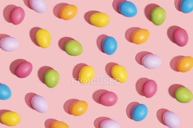 Многоцветные пасхальные яйца на розовом фоне — стоковое фото
