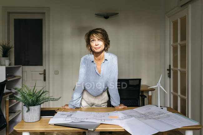 Engenheira feminina apoiada na mesa enquanto estava no escritório — Fotografia de Stock