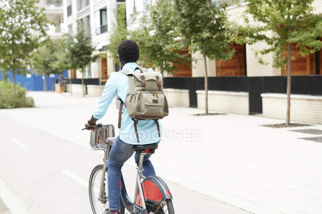 Homme avec sac à dos se déplacer à vélo en ville — Photo de stock