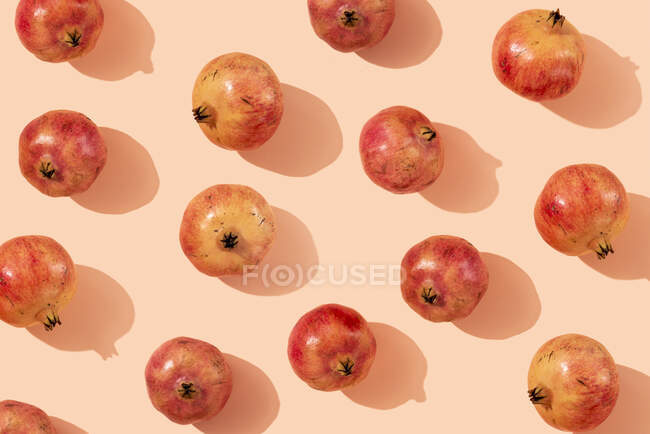 Ripe pomegranates arranged on beige background — Stock Photo