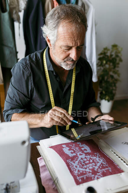 Чоловічий дизайнер костюмів за допомогою цифрового планшета, що працює в студії — стокове фото