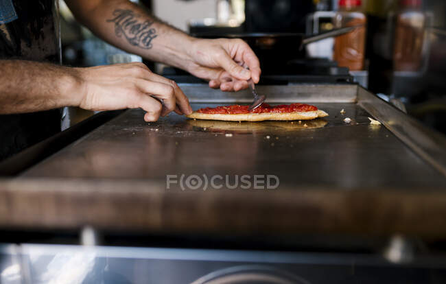 Чоловік шеф-кухар готує томатний сендвіч у кав'ярні. — стокове фото