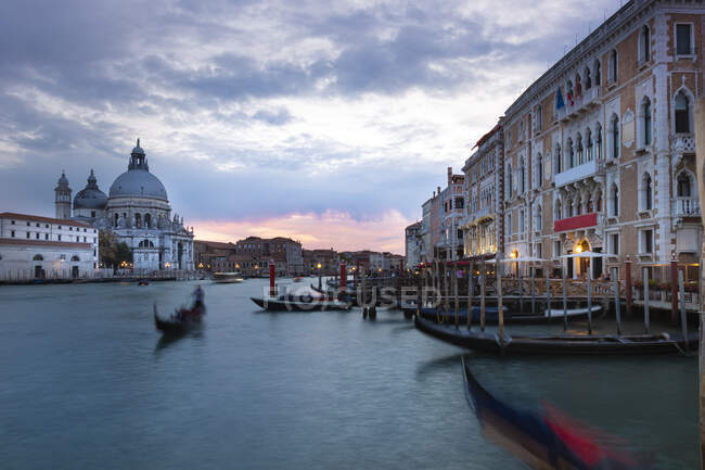 Italy, Veneto, Venice, Gondolas moored in marina in front of Santa Maria della Salute at dusk — Stock Photo