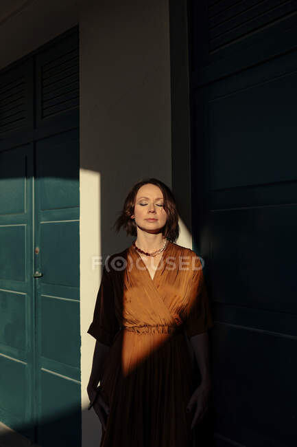 Жінка з заплющеними очима стоїть біля дверей на курорті в Довіллі (Франція). — стокове фото
