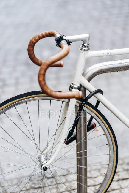 Racing bicycle locked to bicycle rack — Stock Photo