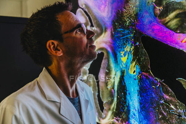 Науковець, стоячи в лабораторії, досліджує проекцію людського мозку нервовими волокнами. — стокове фото