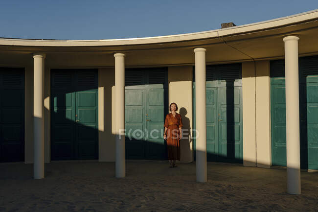 Mid adult woman standing against door in resort at Deauville, France — Stock Photo