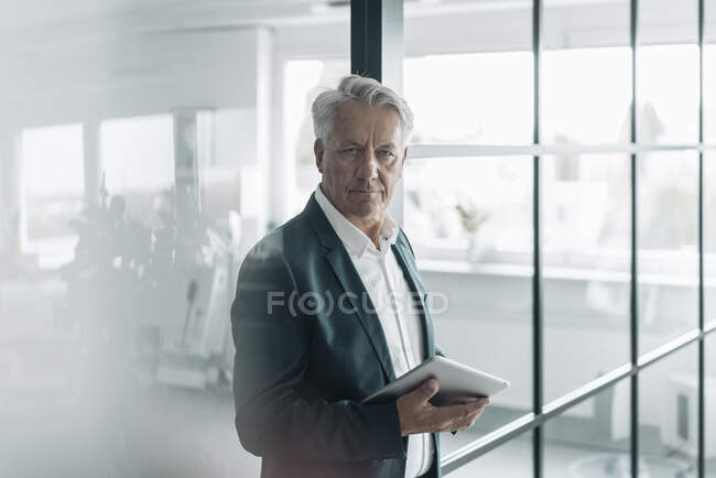 Uomo d'affari che utilizza tablet digitale mentre in piedi in ufficio — Foto stock