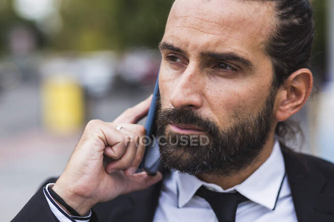 Retrato del hombre barbudo hablando por teléfono inteligente - foto de stock