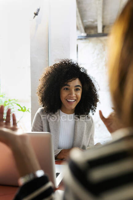 Colleghi sorridenti discutono mentre sono seduti in un caffè — Foto stock