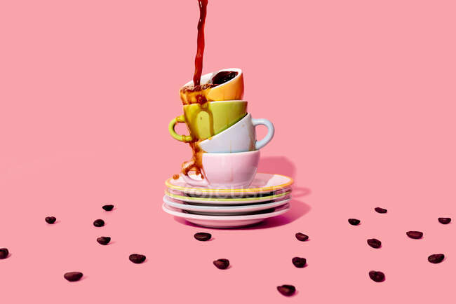 Студийный снимок кофе, льющегося на стопку тарелок и кофейных чашек — стоковое фото
