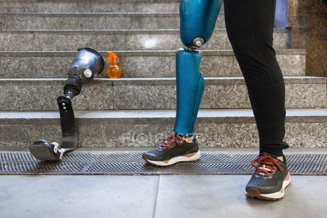 Jeune sportive avec prothèse de jambe debout par un membre artificiel sur les marches — Photo de stock