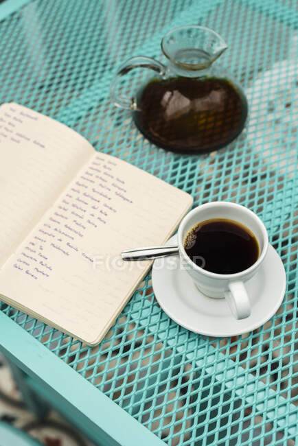 Vista de alto ângulo do livro, xícara de café e pote mantidos na mesa — Fotografia de Stock