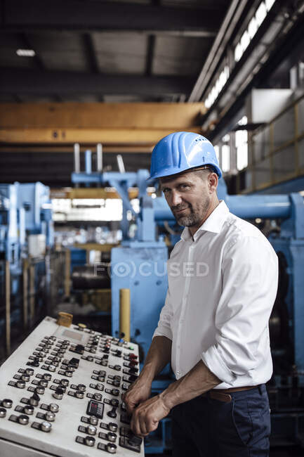 Male entrepreneur operating control panel while standing at industry — Stock Photo