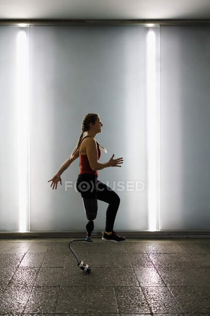 Sportswoman avec jambe prothétique en cours d'exécution sur le sentier dans le passage inférieur — Photo de stock