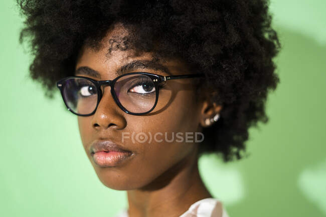 Nahaufnahme einer Frau mit Brille vor grünem Hintergrund — Stockfoto