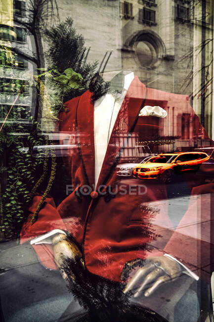 Roter Anzug auf Schaufensterpuppe durch Schaufenster mit Reflexion des Gebäudes gesehen, New York, USA — Stockfoto