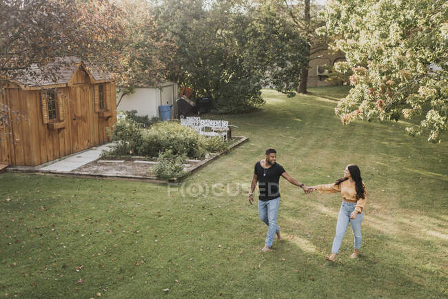 Пара тримається за руку, ходячи на подвір 
