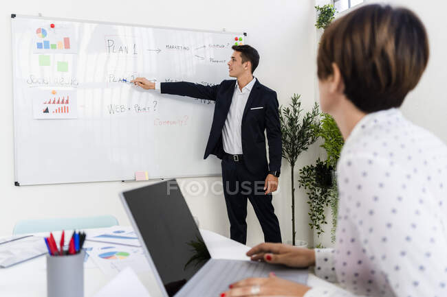 Jovem empresário explicando plano para colega durante reunião — Fotografia de Stock
