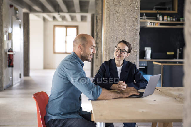 Gli uomini d'affari discutono durante l'utilizzo di laptop in ufficio — Foto stock
