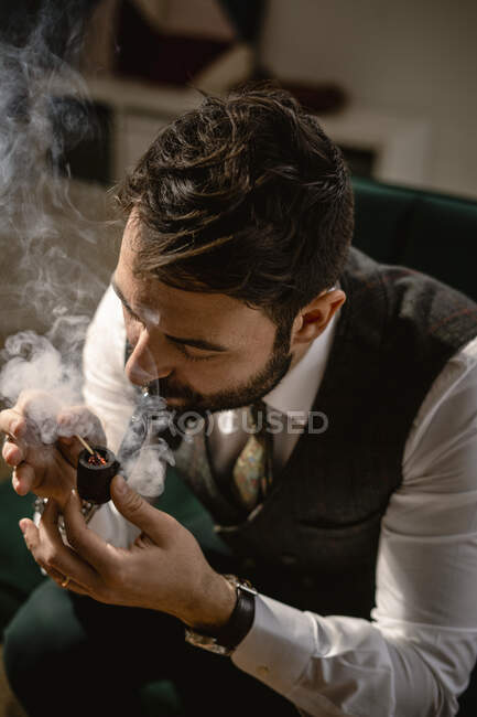 Bearded man smoking pipe — Stock Photo