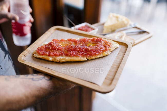 Camarero sirviendo sándwich de tomate en cafetería - foto de stock