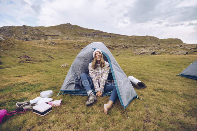 Young woman sitting in tent on mountain around Ibones of Anayet — Stock Photo