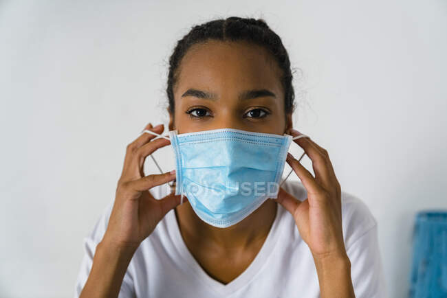 Jeune fille portant un masque protecteur debout contre le mur — Photo de stock