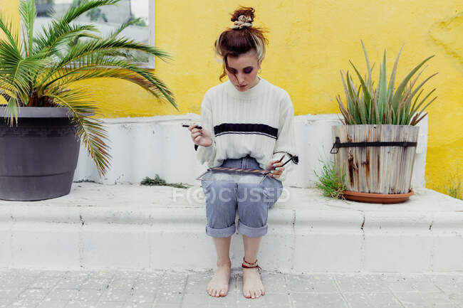 Giovane donna seduta con make up tavolozza nel cortile posteriore — Foto stock