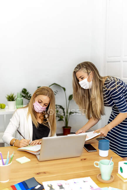 Бізнесмени, які носять маску обличчя, працюють в офісі. — стокове фото