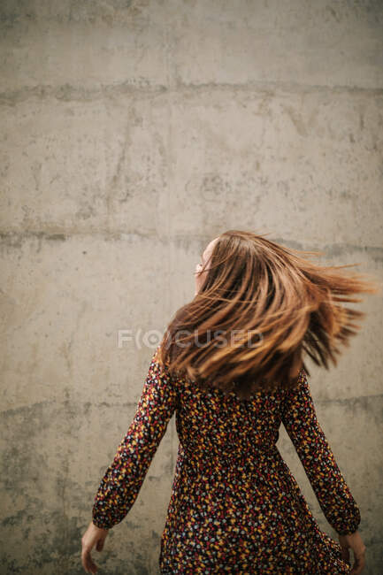 Беззаботная женщина бьет волосами об стену — стоковое фото