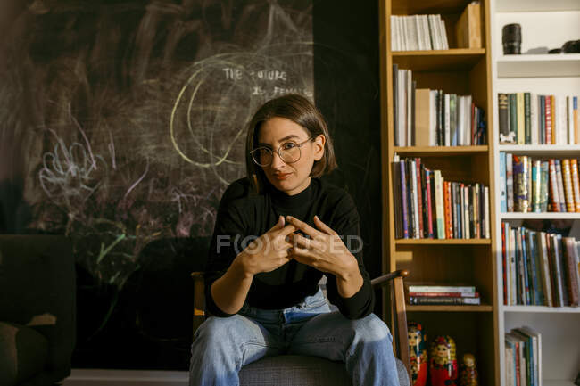 Contemplando mulher sentada na cadeira em casa — Fotografia de Stock