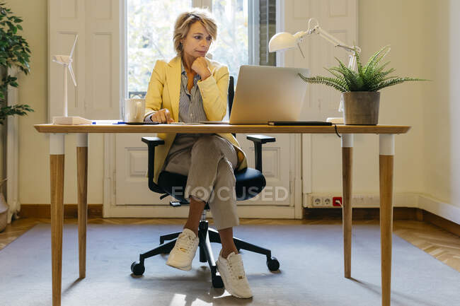 Ragionevole ingegnere donna che lavora sul computer portatile mentre è seduto in ufficio — Foto stock
