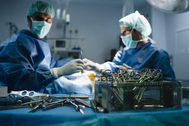 Чоловічий хірург передає медичне обладнання під час операції в операційній. — стокове фото