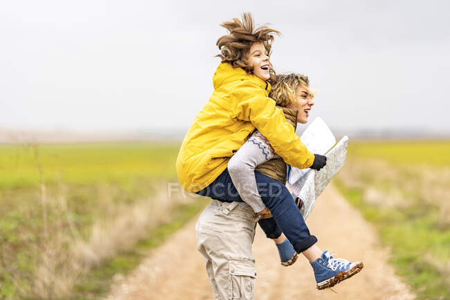 Young man piggybacking younger brother during hike — Stock Photo