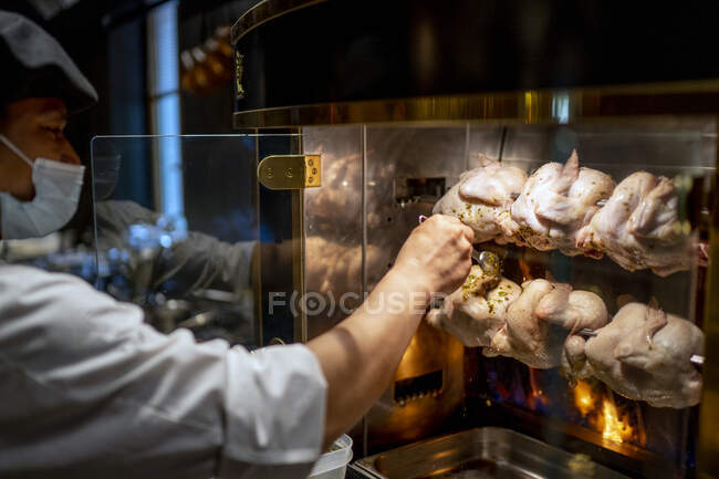 Chef adulto médio marinando frango tandoori no restaurante — Fotografia de Stock