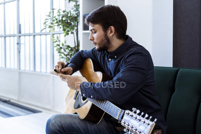 Compositeur masculin écrivant de la musique dans un bloc-notes assis au studio — Photo de stock
