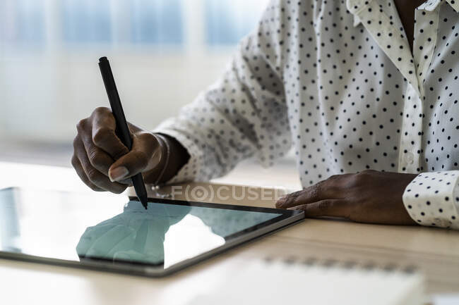 Escritura a mano femenina en tableta digital en la sala de estar en casa - foto de stock